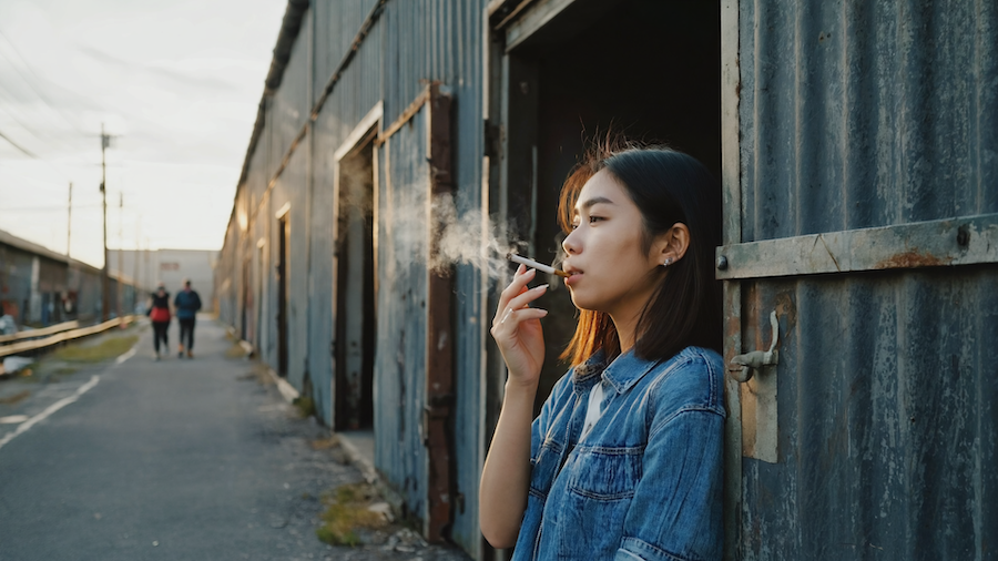 Person holding a vape cart with Midtown Atlanta skyline view