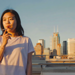Adults enjoying cannabis on an Atlanta rooftop with skyline backdrop